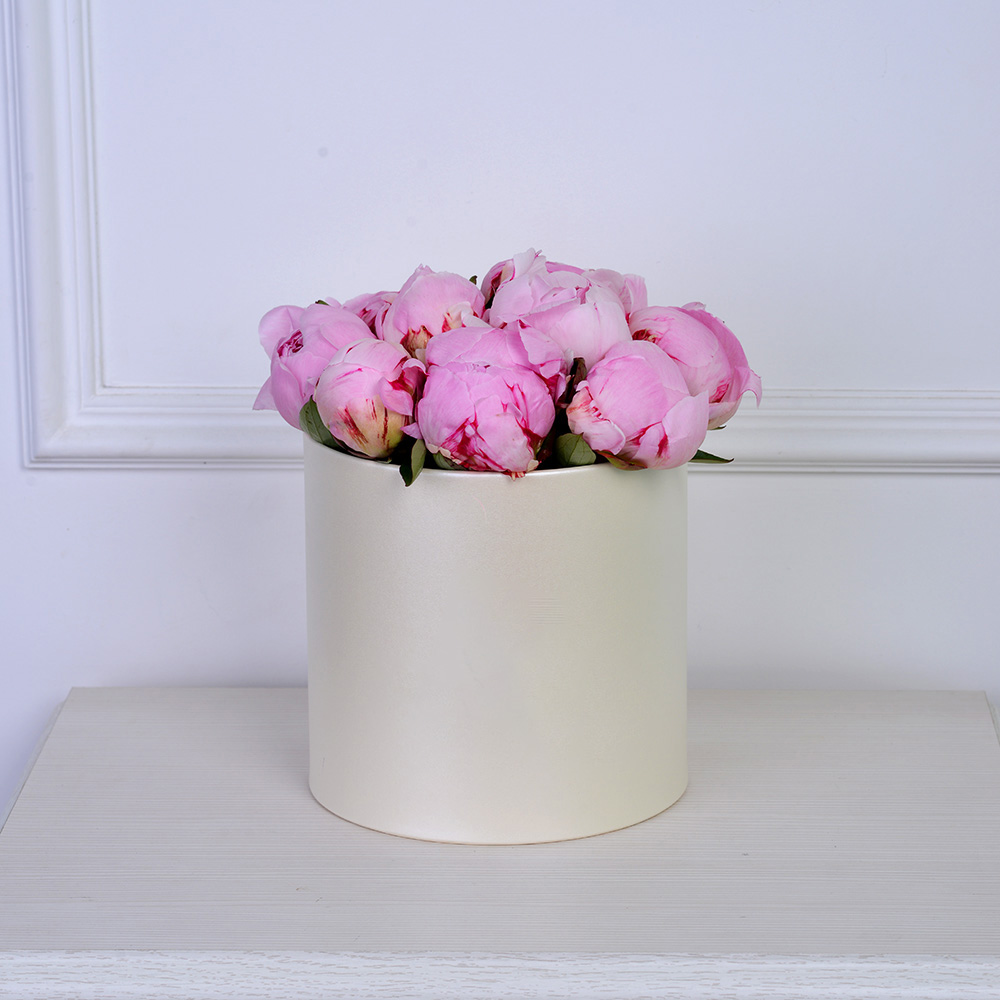 Букет из 11 розовых пионов в кремовой шляпной коробке