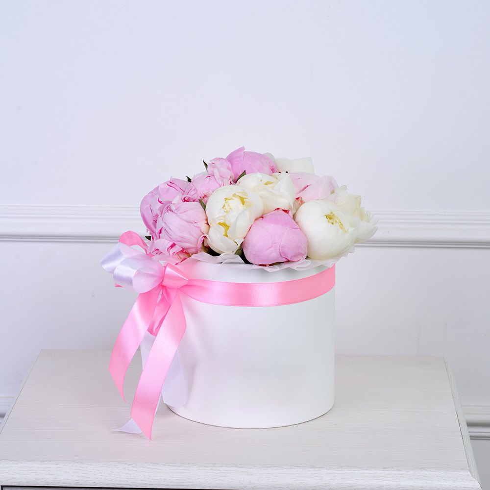 Букет из 11 разноцветных пионов в белой шляпной коробке