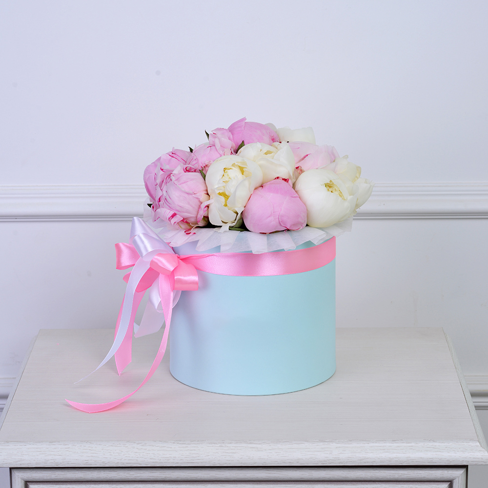 Букет из 11 разноцветных пионов в голубой шляпной коробке
